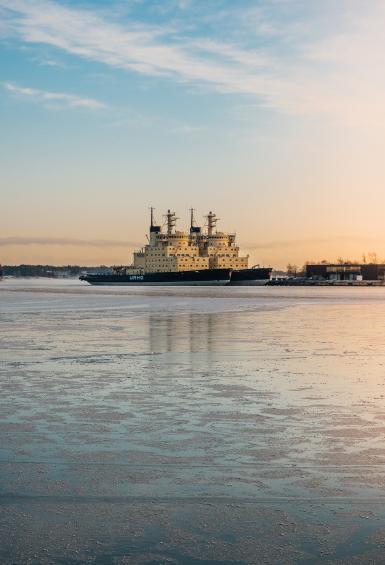 In the distance over the slightly frozen sea, two icebreakers are docked side by side next the Katajanokka shore.
