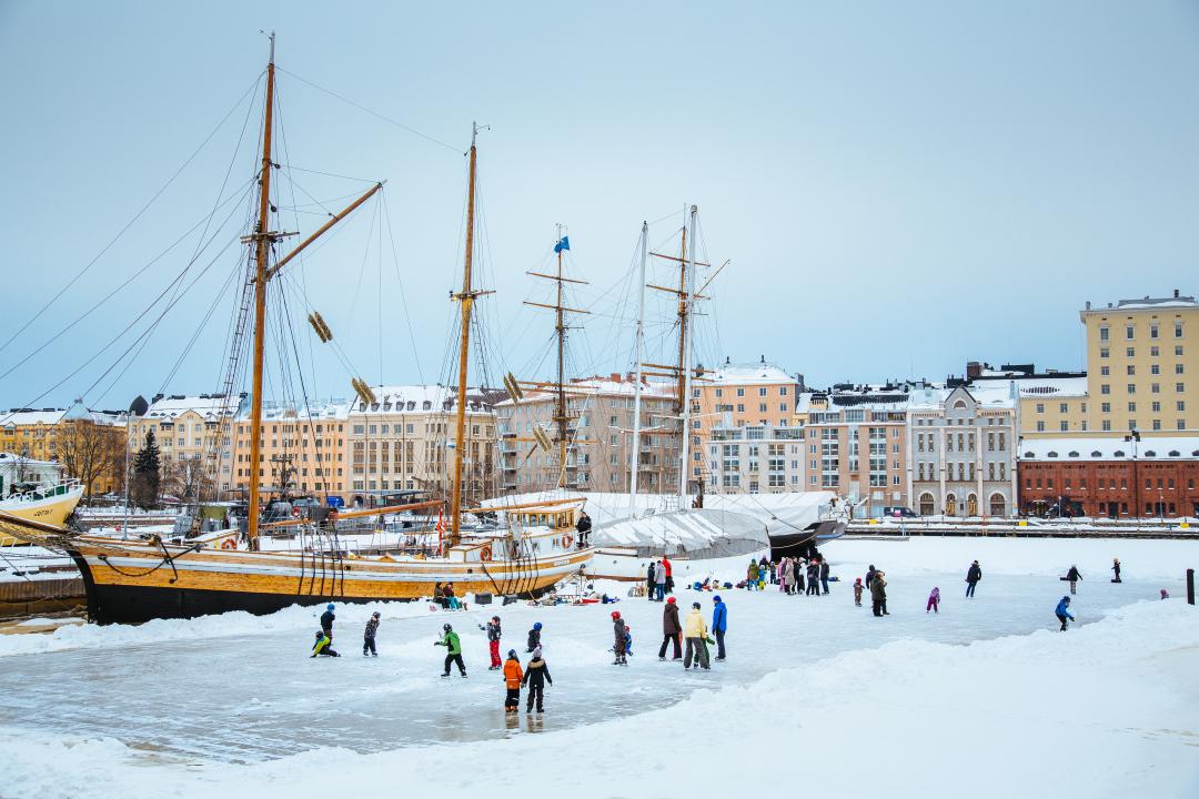 Helsingforsare åker skridsko på isen utanför Vedkajen.