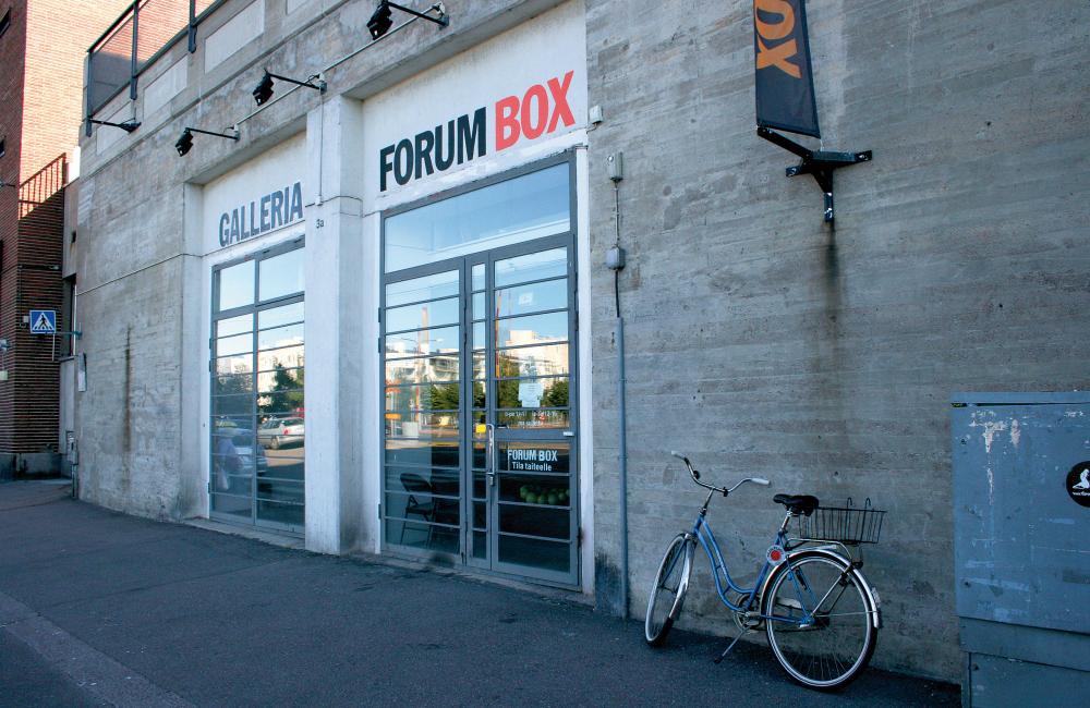 Entrance way to Forum Box art gallery, set within a grey concrete wall, bicycle leaning against the wall.