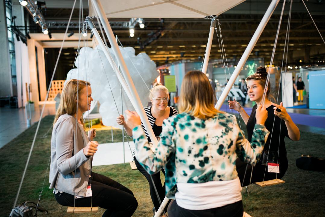 Four women discuss ideas for new city services whilst facing each other on swing seats in an event at Messukeskus.