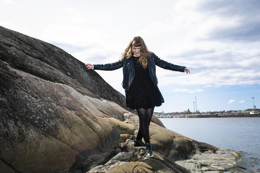 With her hands outstretched, Kaija Rantakari is walking down a small, rocky slope on the shore of one of Helsinki's harbours.