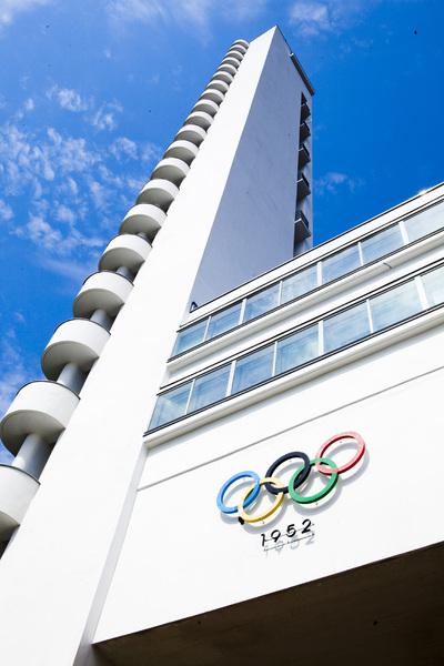 A portrait image of the white tower of Helsinki Olympic Stadium, blue sky behind it.