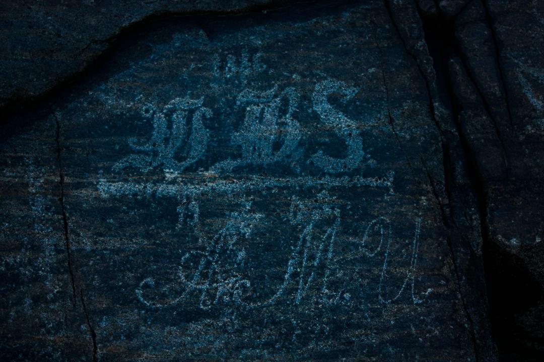 Close up of carvings found on the Ursin rocks spelling out initials in old, script like fonts.