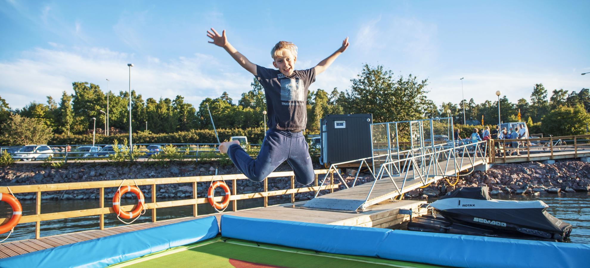 A boy jumping on the water trampoline.